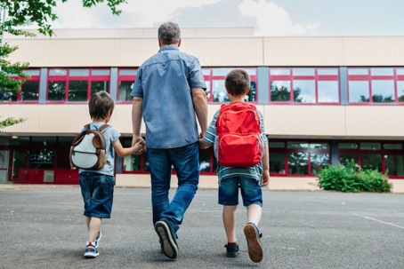 dad escorts his sons to school